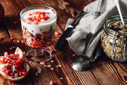 Prepared Dessert with Ingredients on Wooden Table. Series on Prepare Healthy Dessert with Pomegranate, Granola, Cream and Jam