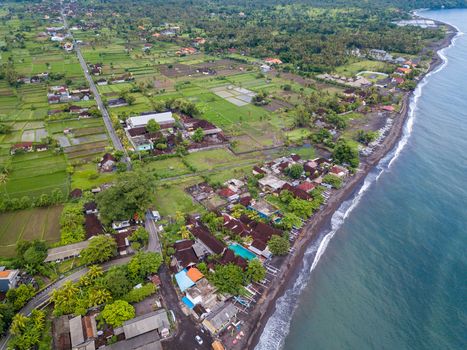 Aerial view of Amed beach in Bali, Indonesia. Traditional fishing boats called jukung on the black sand beach.