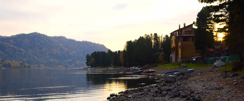 East rocky shore of Lake Teletskoye, cliffs covered with a beautiful forest. The picture was taken on an autumn day, with natural light.