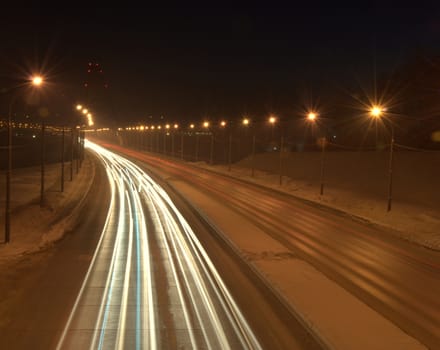 Light tracks from the headlights of cars passing by. The picture was taken at night on a long exposure. Bugrinsky Bridge, Novosibirsk, Russia.