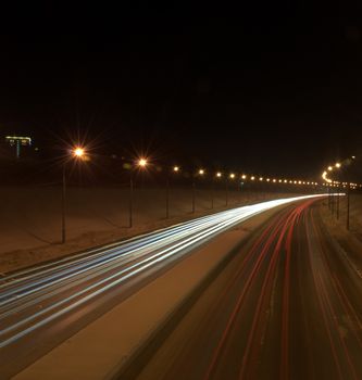 Light tracks from the headlights of cars passing by. The picture was taken at night on a long exposure. Bugrinsky Bridge, Novosibirsk, Russia.