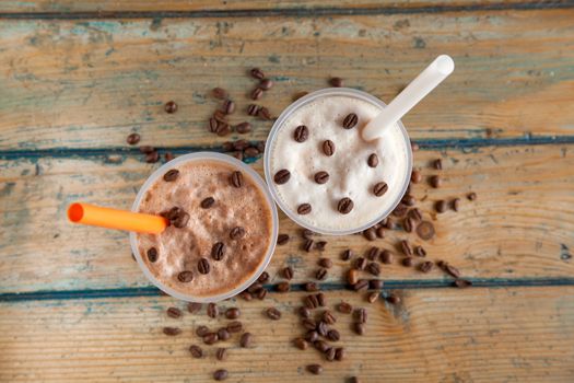 Iced frappes with coffee beans spilled top angle