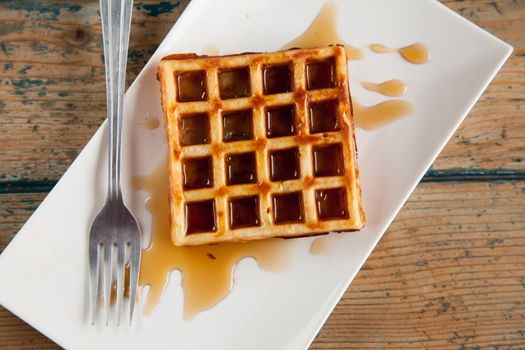 Waffle with maple syrup fork plate top angle
