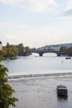 Beautiful Prague City View along the river with tourist boat