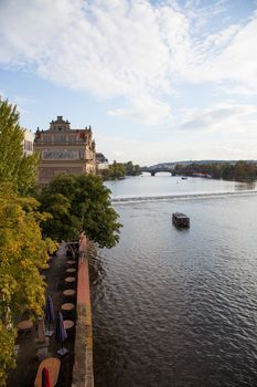 Beautiful Prague City View along the river with tourist boat