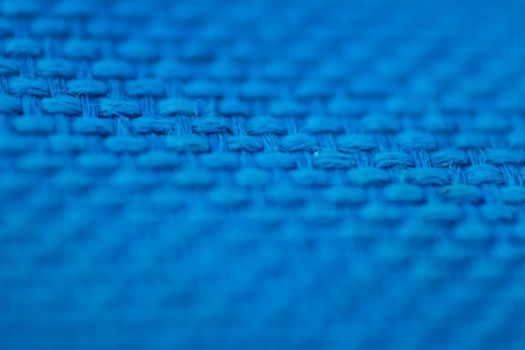 a macro shoot of braided blue cloth texture with vivid colors. focus on mid of picture.