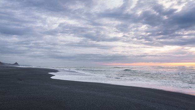 A Black Sand Beach At Sunset, Color Image.