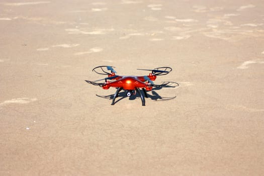 orange drone standing on the sand. Sunny day