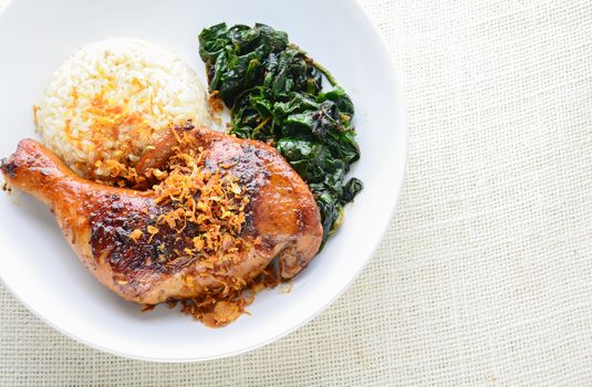Chicken drumstick marinated with spicy chilli sauce and herbs, served with cooked rice and spinash.