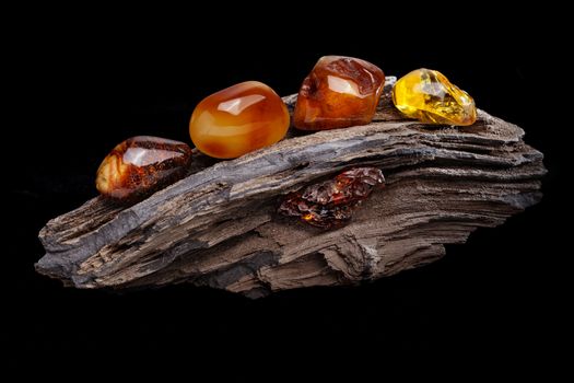 Composition of several pieces of natural amber. Various colors from transparent yellow to dark red, polished with signs of natural origin such as cavity and superficial cracks on its surfaces.