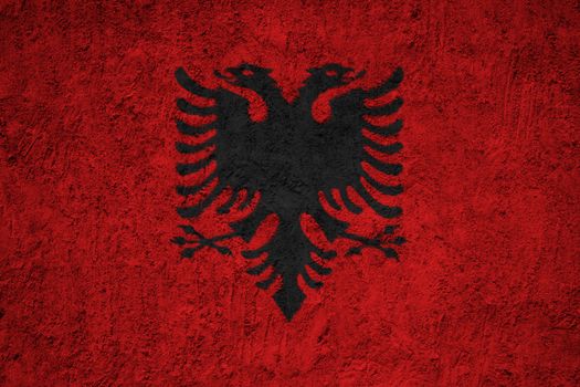 Albania flag painted on the cracked grunge concrete wall