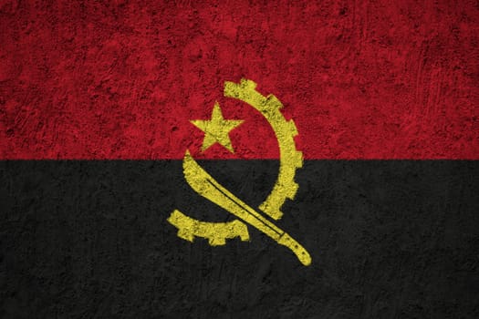 Angola flag painted on the cracked grunge concrete wall