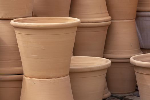 Rustic terracotta pots piled up on display closeup full frame