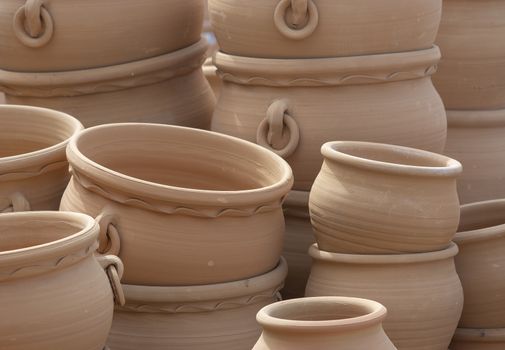 Rustic terracotta pots piled up on display closeup full frame