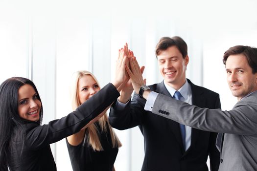 Happy business team giving high five in office , success and winning concept