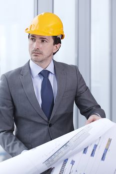Architector in hardhat and business suit with construction plans