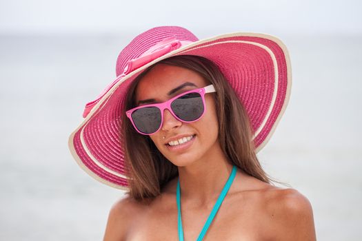 Portrait of a beautiful smiling young woman in bikini and sunhat