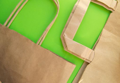 Zero waste, plastic free recycled production bag into paper bag, environmental protection concept, top view, green background, flat lay, copy space