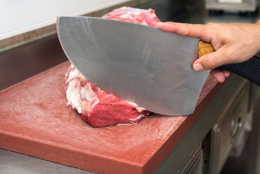 butcher cutting steaks at the butcher shop