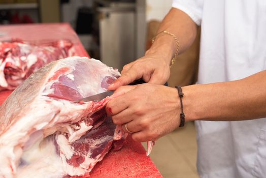 butcher cutting a large piece of meat