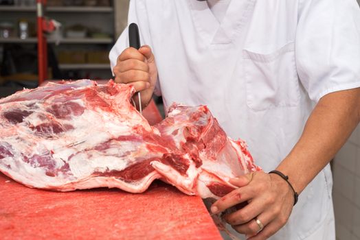 butcher cutting a large piece of meat