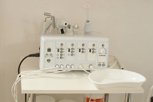 Cosmetic Multifunctional Device close-up in beauty salon. Ultrasound medical device. Darsonval device. Ultrasound procedure. Medical equipment healthcare. Young skin. Face professional massage.