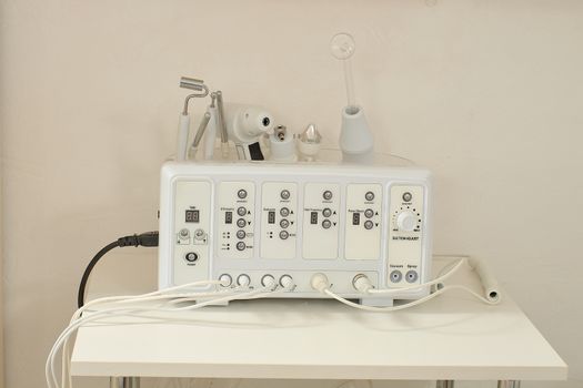 Cosmetic Multifunctional Device close-up in beauty salon. Ultrasound medical device. Darsonval device. Ultrasound procedure. Medical equipment healthcare. Young skin. Face professional massage.