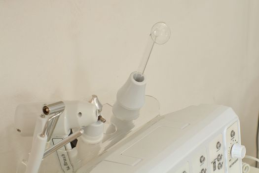 Cosmetic Multifunctional Device close-up in beauty salon. Ultrasound medical device. Darsonval device. Ultrasound procedure. Medical equipment healthcare. Young skin. Face professional massage.