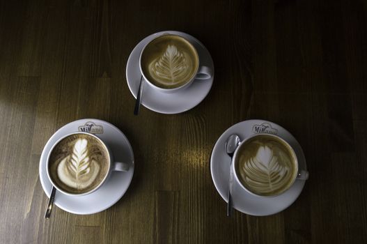 Brown has been placed on a tabletop, three white cup coffee with milk