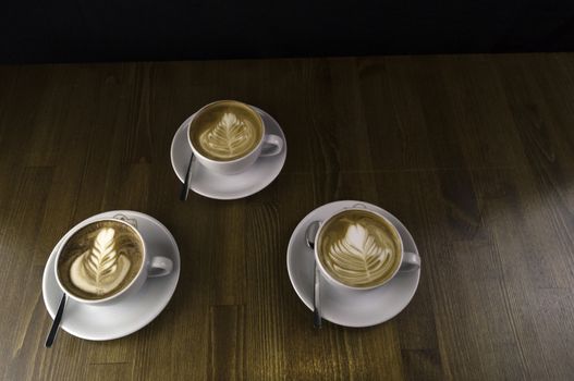 Brown has been placed on a tabletop, three white cup coffee with milk