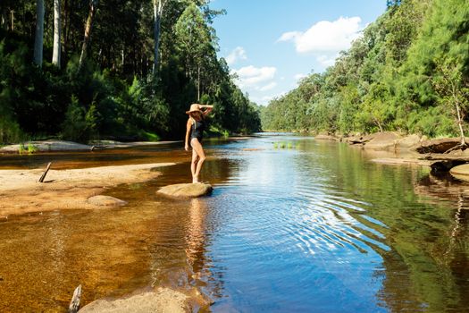 A woman enjoys the cooling tranquil waters of a secluded spot of the  Grose River after hiking down the mountain into the valley -  Blue Mountains, Australia