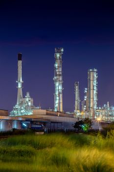 night view after sunset time with agriculture field and chemical plant petrochemical and petroleum plant with reactor and distillation for chemical process in industrial area and technology concept