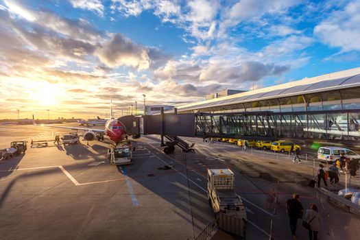 Passenger walk to plane on taxi gate for travel and transportation with service car at Copenhagen airport in Copenhagen city, Denmark, Europe, Scandinavia at beautiful sunset time