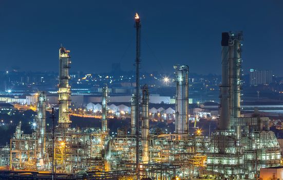 Oil refinery industry for distillate crude oil to gasoline for energy business and transportation, after sunset time and industrial zone in background