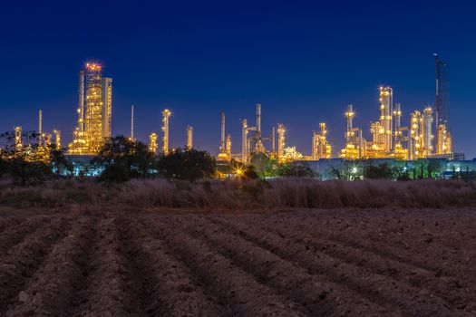 night after sunset time with agriculture field and chemical plant petrochemical and petroleum plant with reactor and distillation for chemical process in industrial area