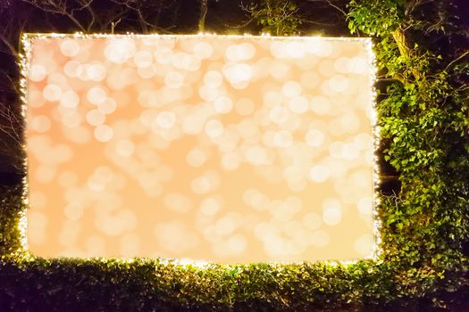 Billboard in a hedge edged with a fairy lights on a building with clipping path