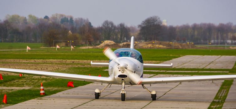 stunt airplane landing on the air strip in closeup, recreational sport and hobby, air transportation background