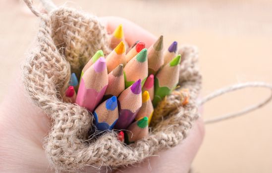 Color Pencils in a linen sack on canvas