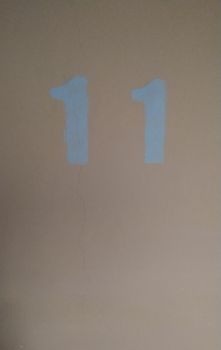 The number 11 in blue on the pink wall. Background, symbol.