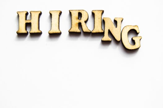 The word hiring is written in gold letters, isolated on white background, copy space, mockup for designer.