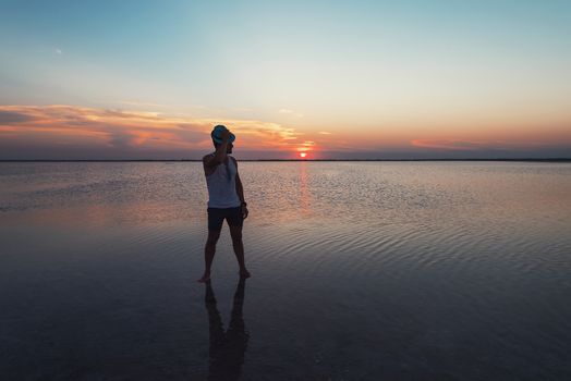 Man walking on salty lake at beauty sunset in Altay, Siberia, Russia