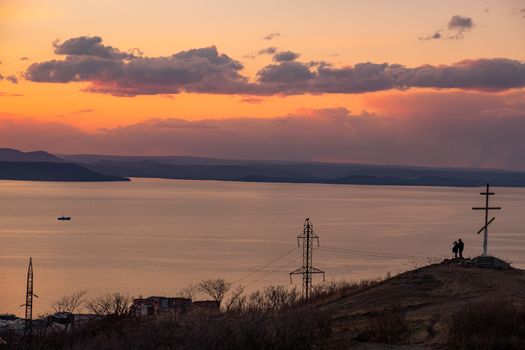 View of the city of Vladivostok from the hill eagle's nest . Sunset. The sky is orange and pink. Sea and city at sunset.