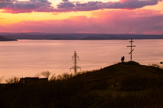 View of the city of Vladivostok from the hill eagle's nest . Sunset. The sky is orange and pink. Sea and city at sunset.