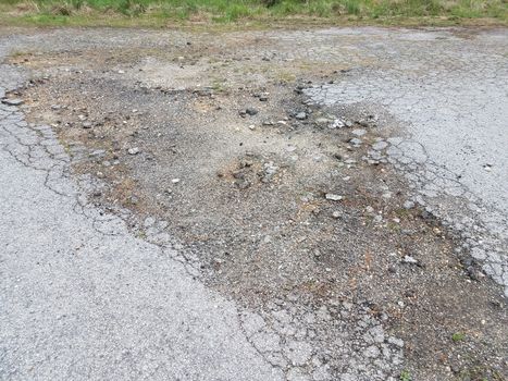 damaged or weathered or worn black asphalt road or street
