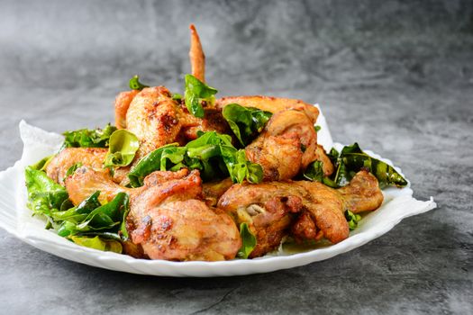 Fried crispy chicken wings, Thigh on white plate with herbs