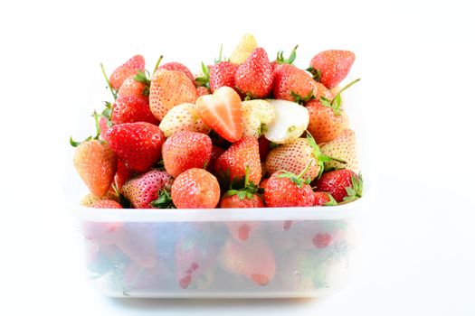 Fresh strawberries in white transparant box on white background