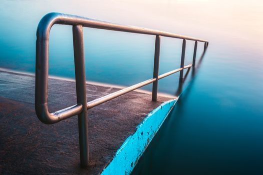 Lovely blues and pinks of the dawn relfected in the North Narrabeen rock pool in the northern beaches of Sydney Australia