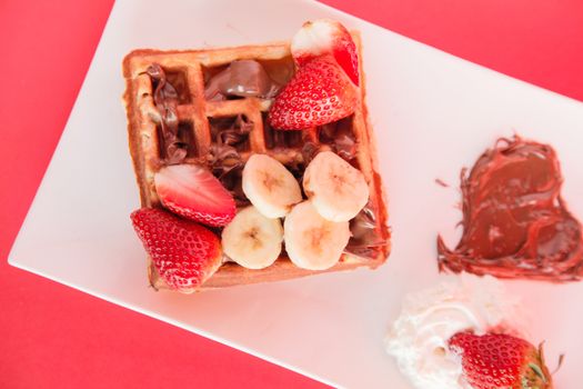 Strawberry and Banana Waffle on red background top view