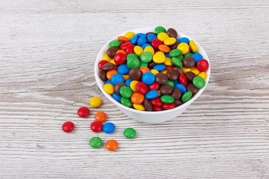 colorful chocolate buttons on wooden background