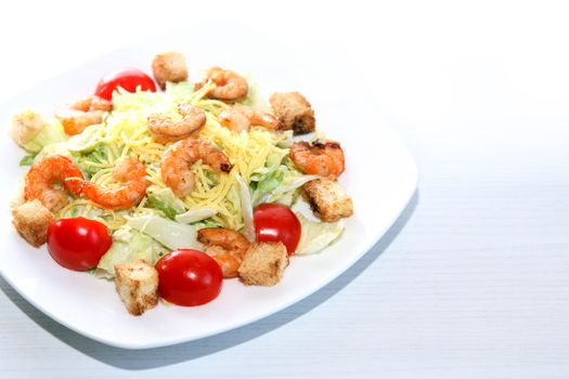 Salad with pasta and shrimps on plate against white background with free space